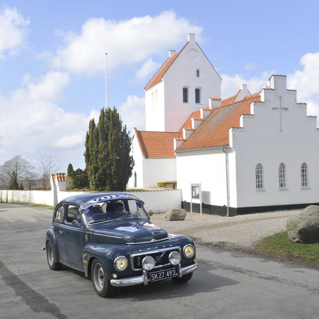 I feltets næstældste bil - en Volvo 544 fra 1965 - vandt Peder Wiihm og Lucas Egholm-Wiihm begynderklassen. Her passerer de Værslev Kirke
(Foto: Morten Alstrup)